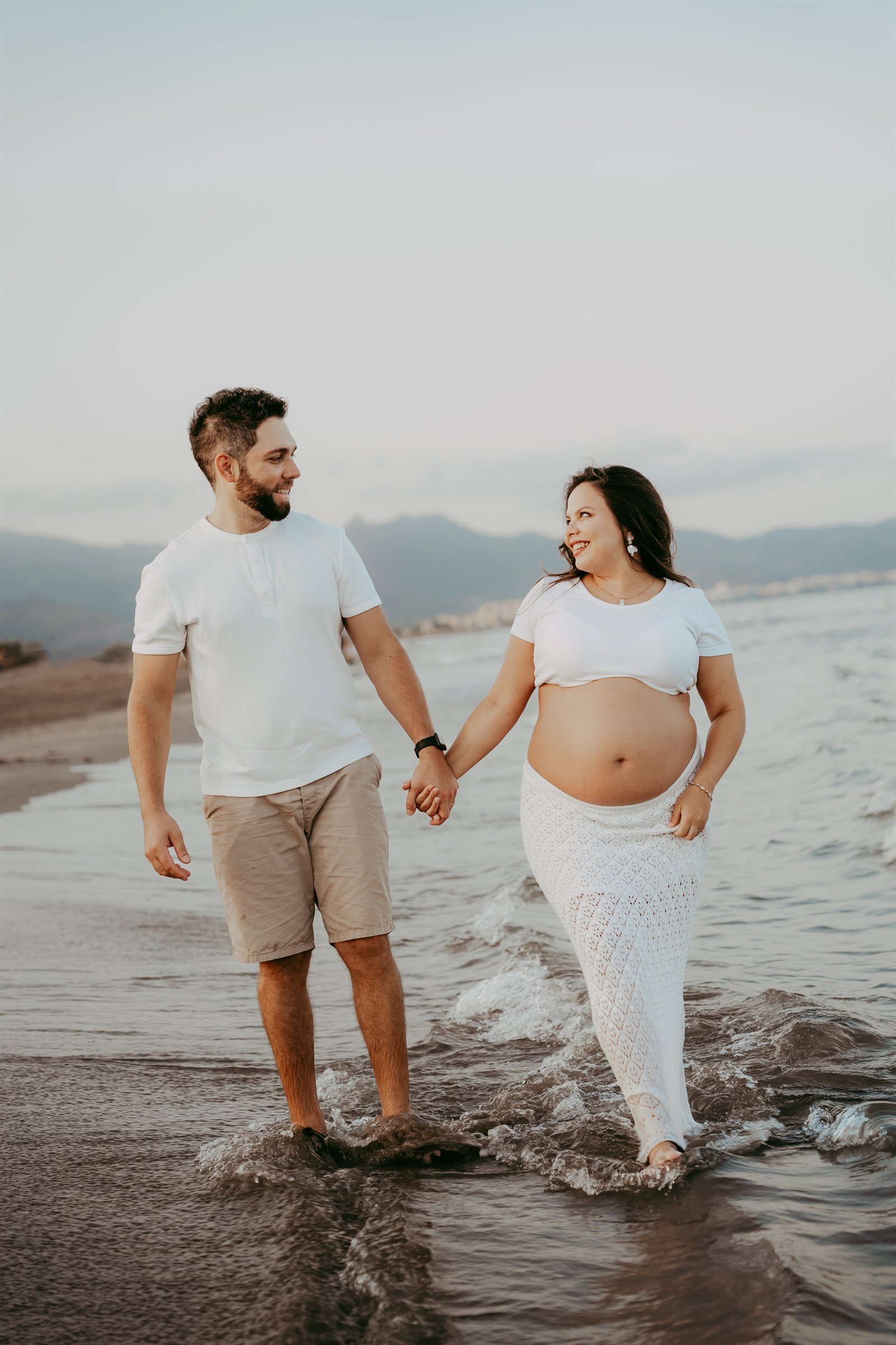 Denis y Virginia pasean de la mano por la orilla