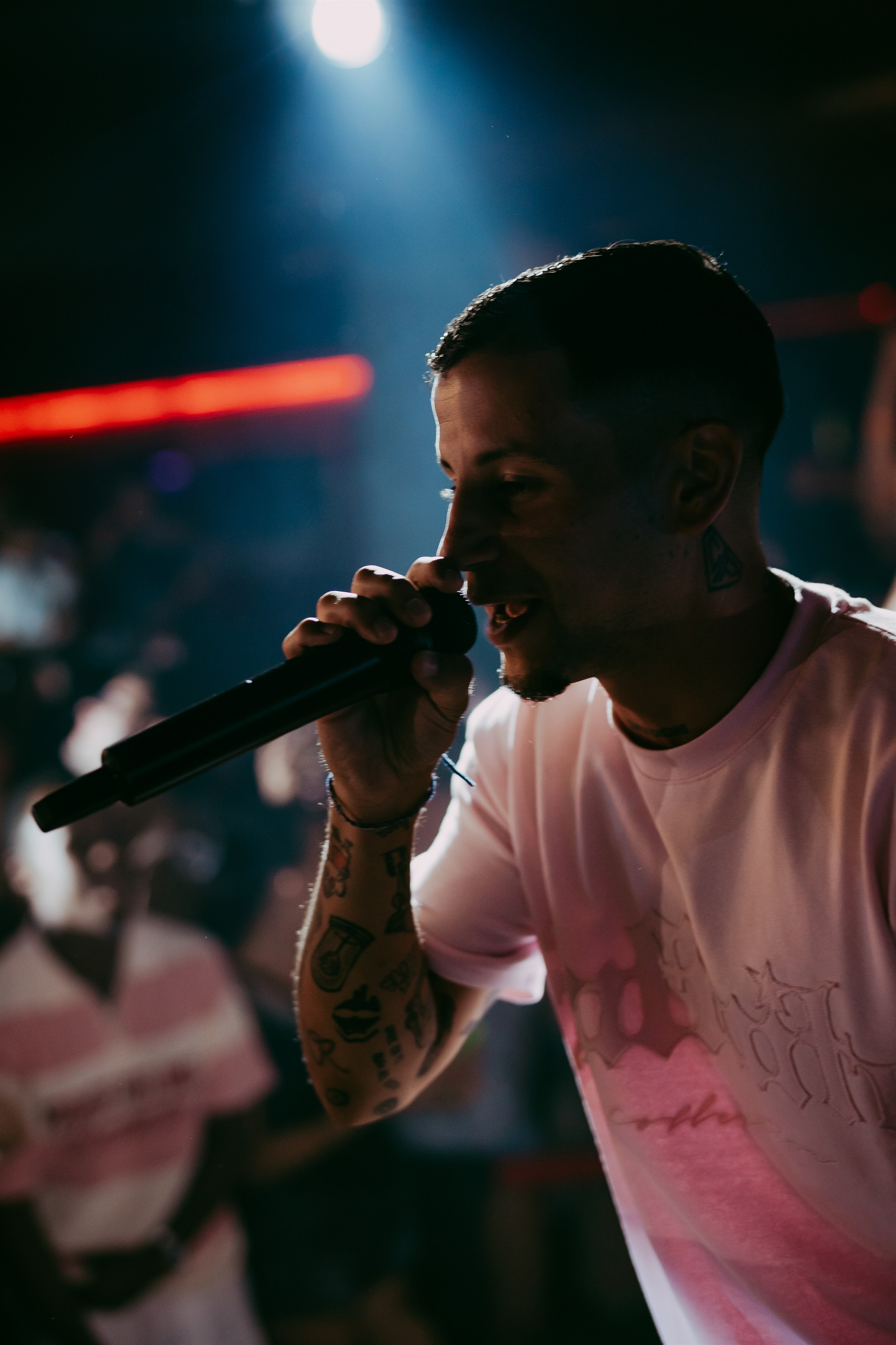 Robledo canta al micrófono bajo luces de escenario